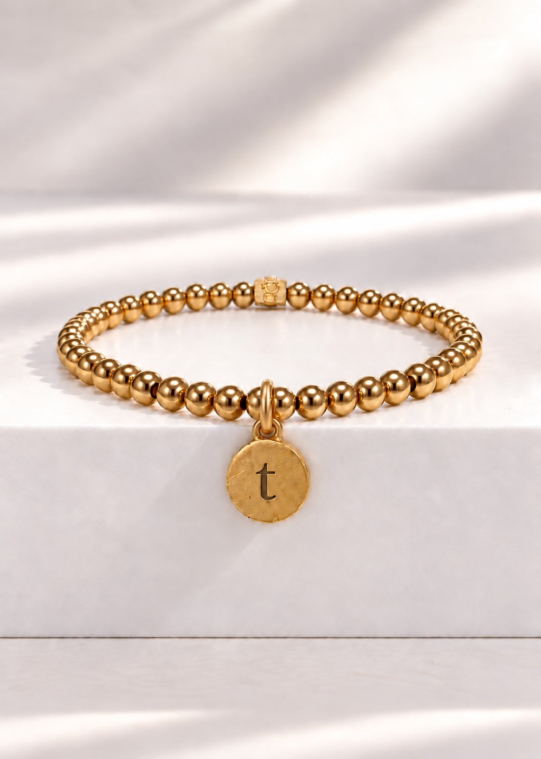 Gold stainless steel beaded bracelet with T initial pendant