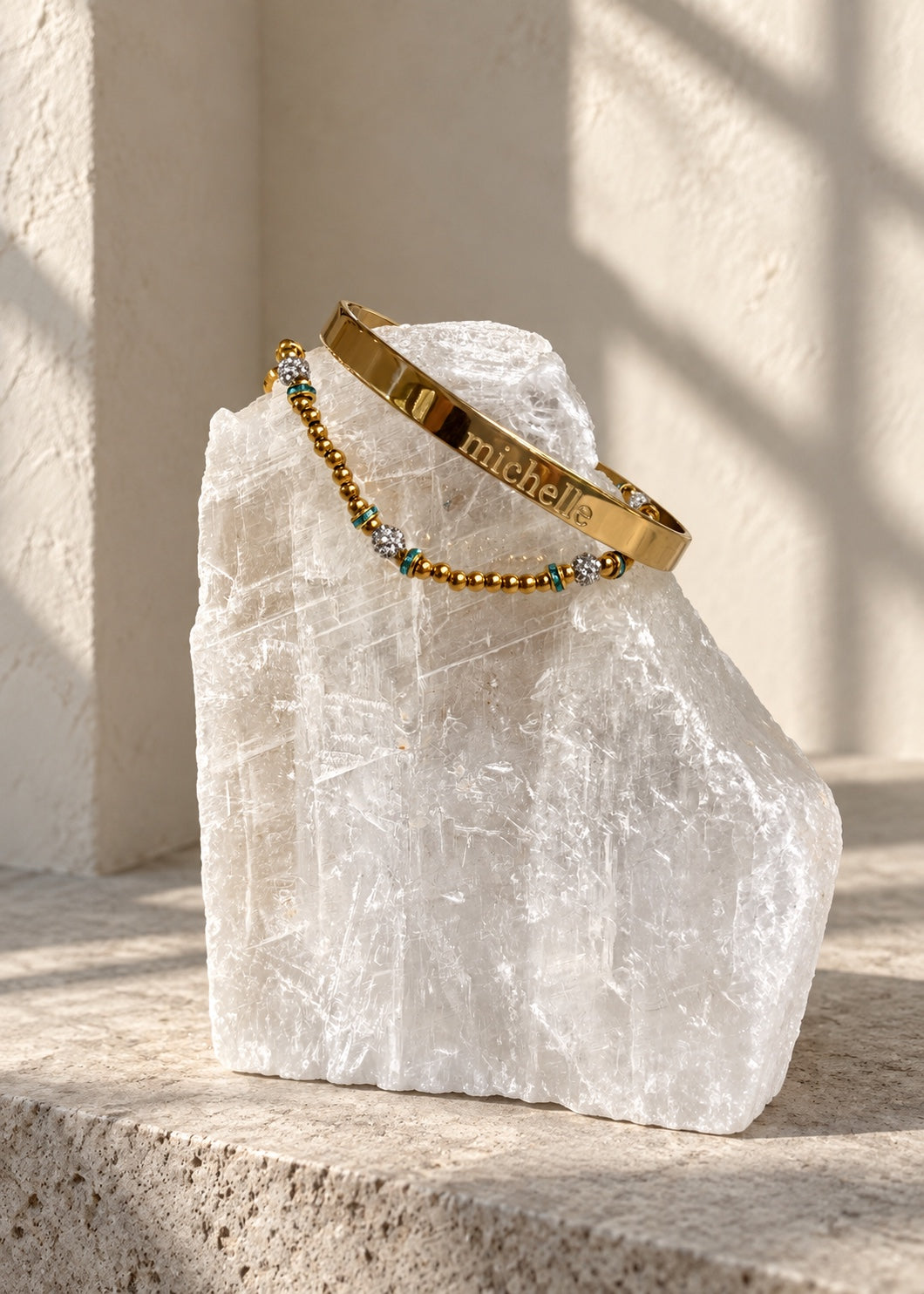Gold engraved name cuff styled on white crystal