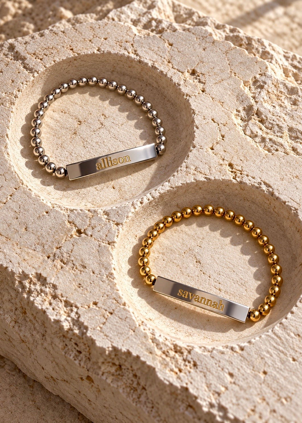 Silver and gold Signature Name Bracelets on a stone tray