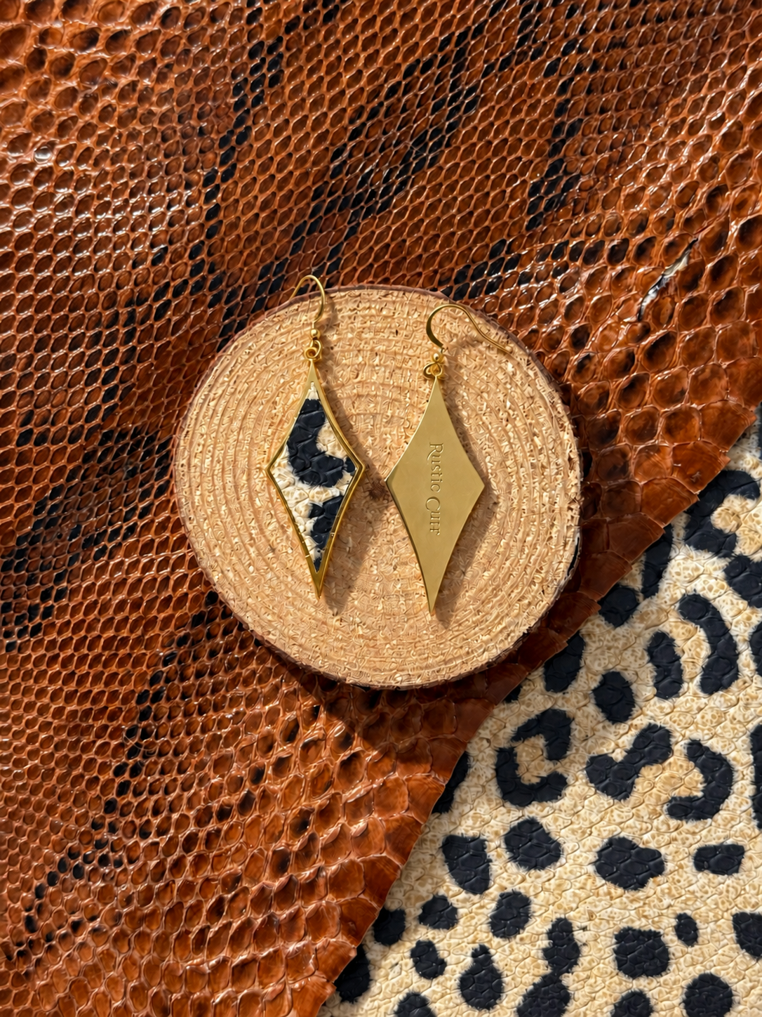 Double Trouble earrings front and engraved back styled on a wood display