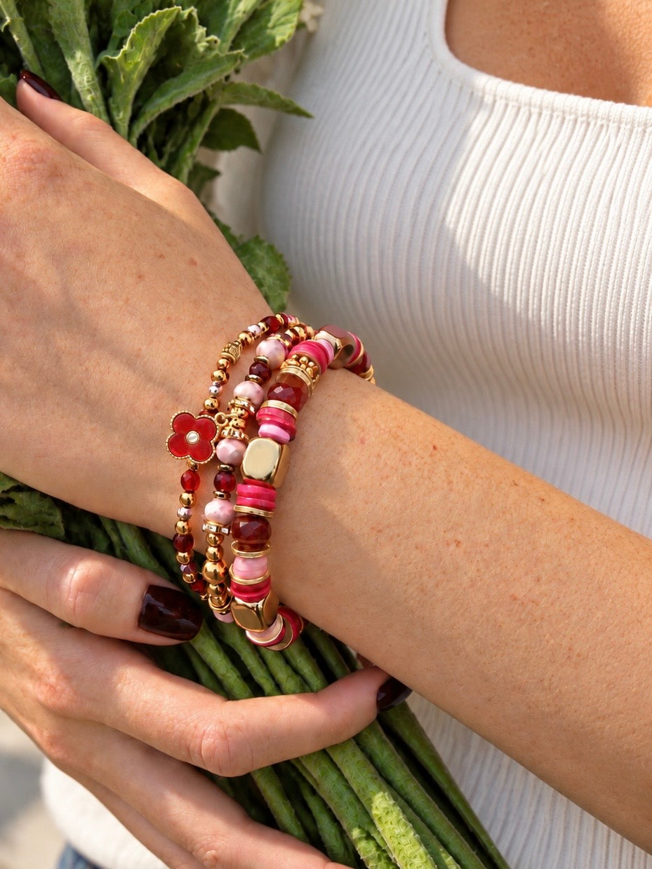 Cue the Confetti, Rooting for You, and Pink Cheers bracelets worn together while holding flowers