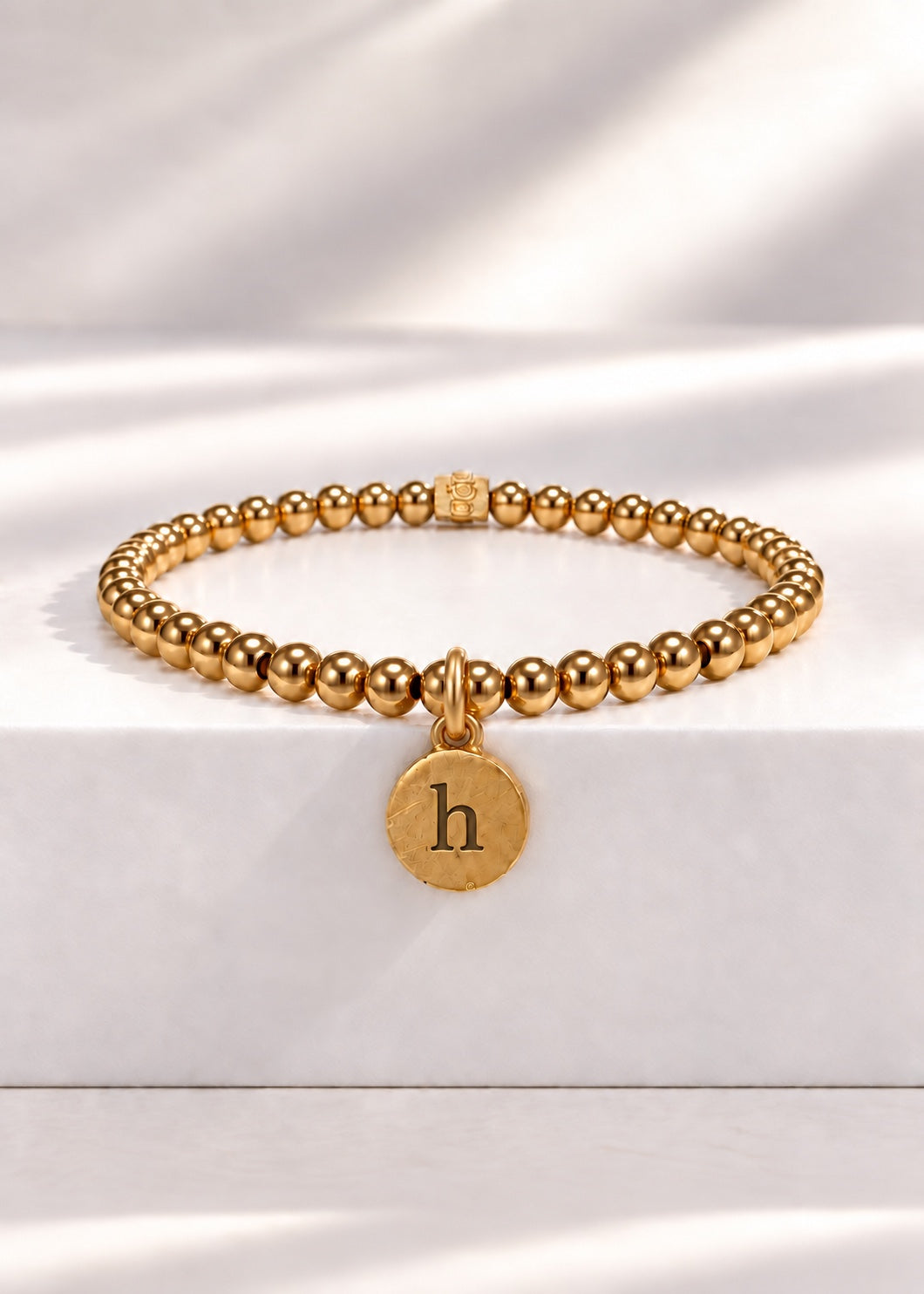 Gold stainless steel beaded bracelet with H initial pendant