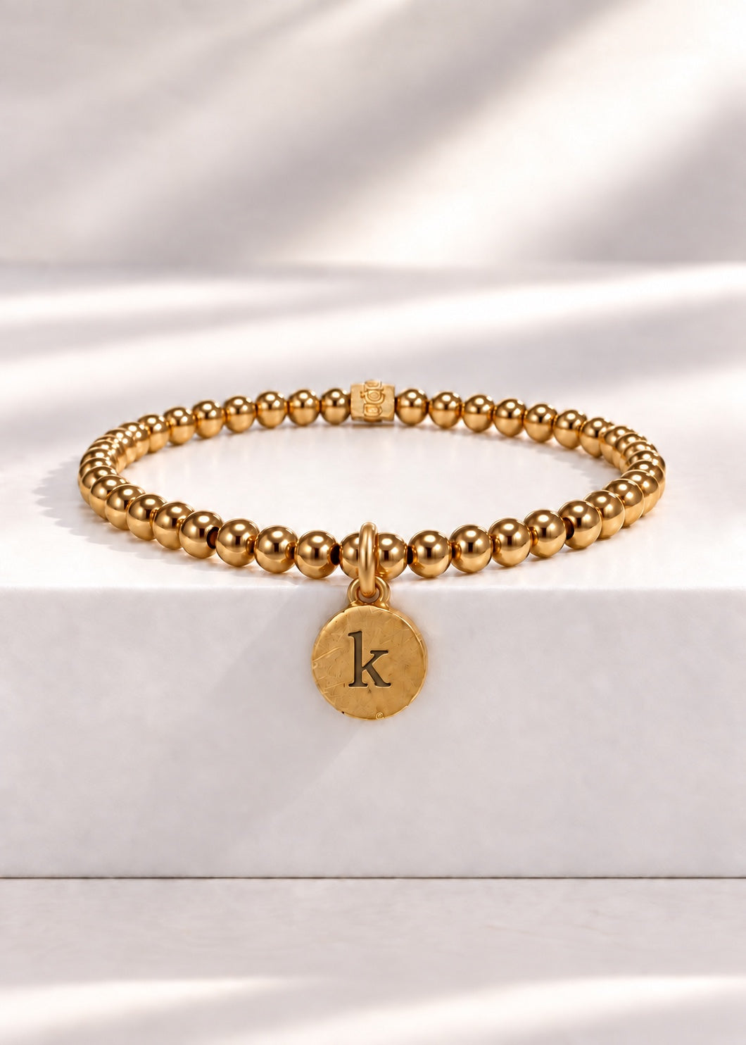Gold stainless steel beaded bracelet with K initial pendant