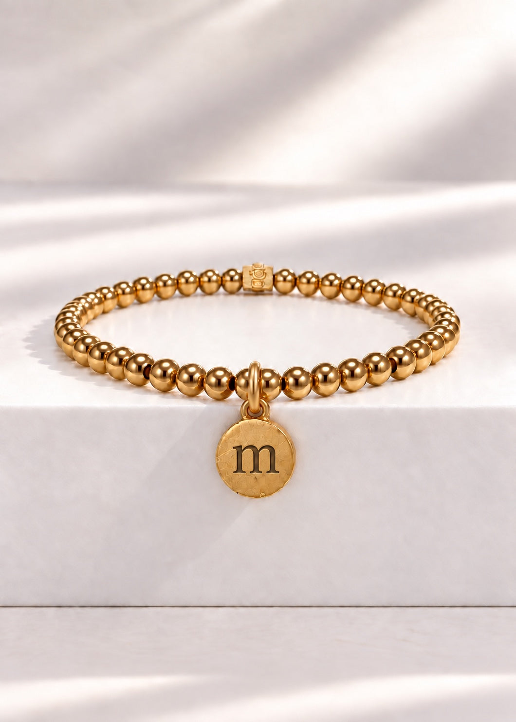 Gold stainless steel beaded bracelet with M initial pendant