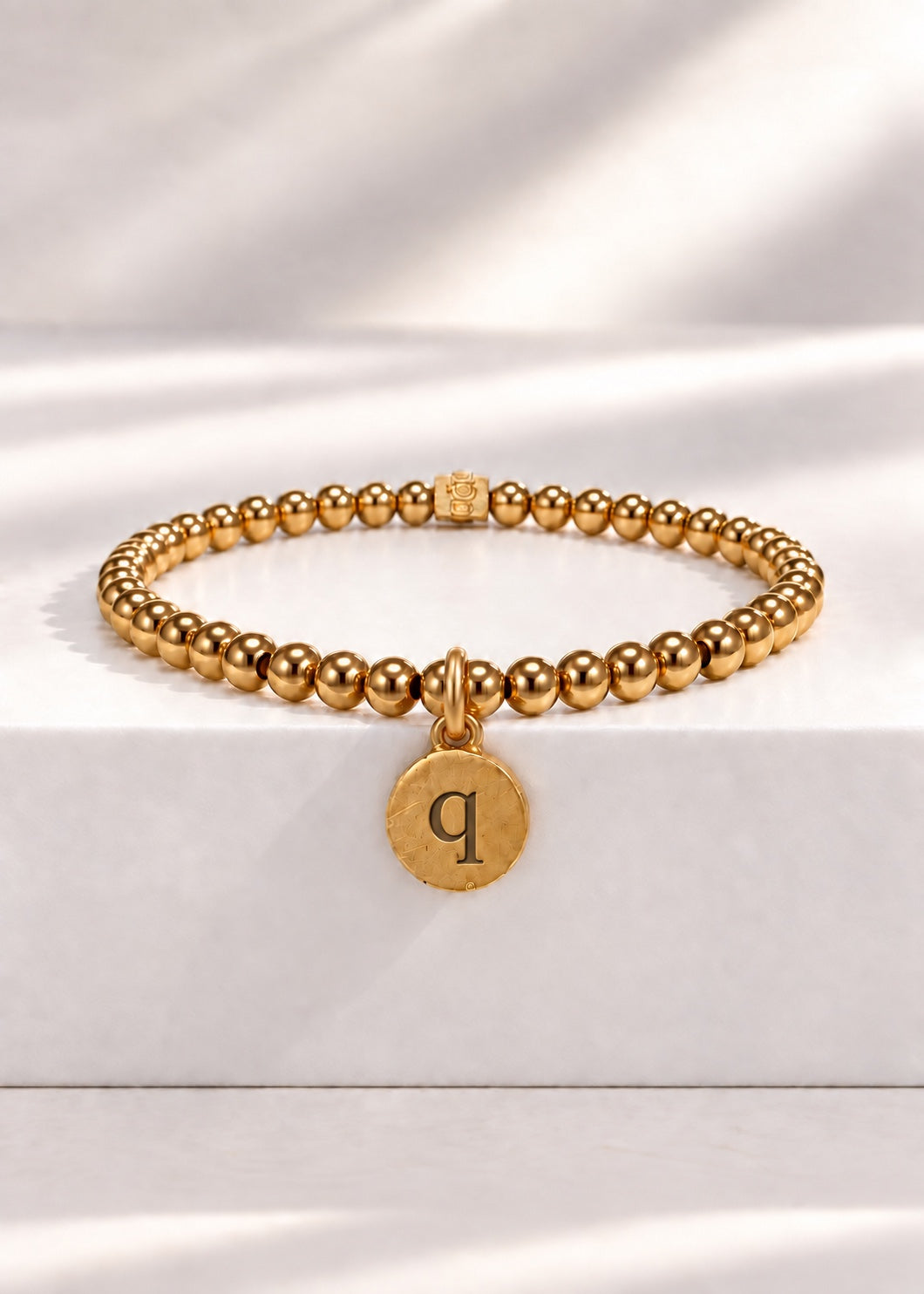 Gold stainless steel beaded bracelet with Q initial pendant