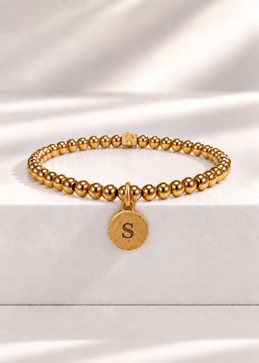 Gold stainless steel beaded bracelet with S initial pendant