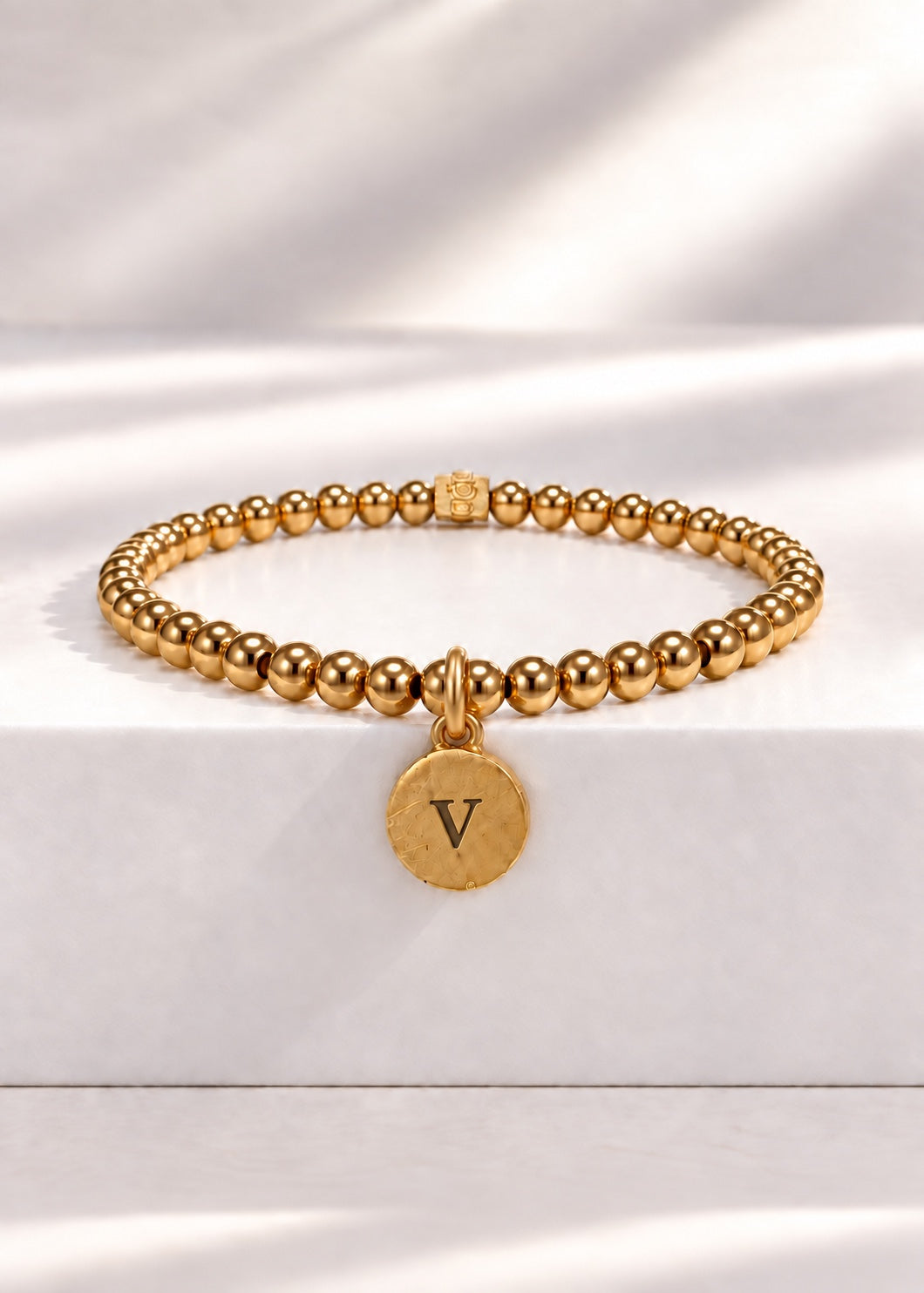 Gold stainless steel beaded bracelet with V initial pendant